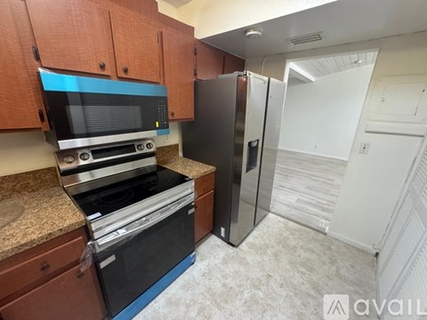 A kitchen with brown cabinets and a black stove top oven.