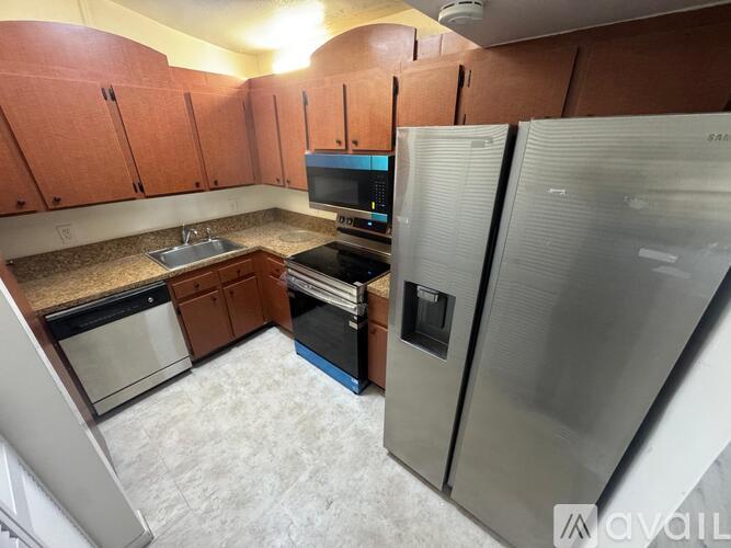A kitchen with a refrigerator, oven, and microwave.