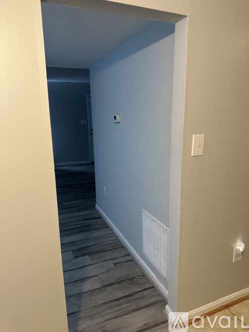 A hallway with a light switch on the wall.