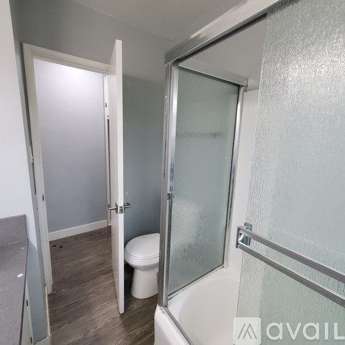 A bathroom with a toilet, a glass shower door, and a walk-in shower.