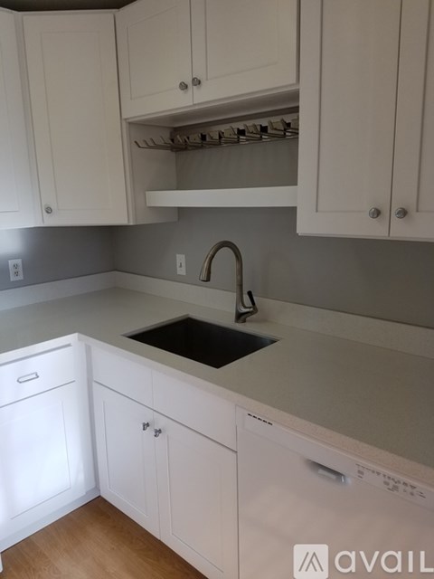 A kitchen with white cabinets and a black dishwasher.