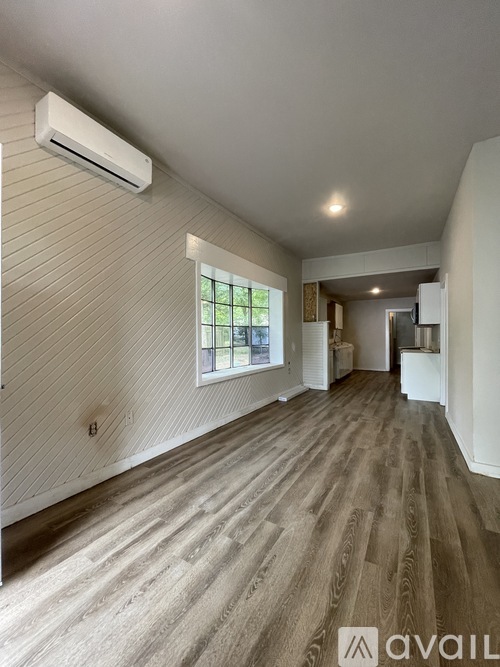 A room with a wooden floor and a window.