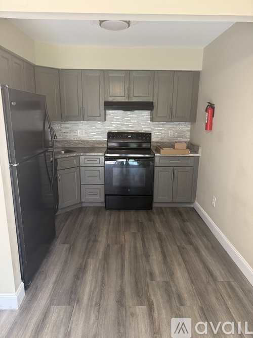 A kitchen with a black stove top oven and a black refrigerator.