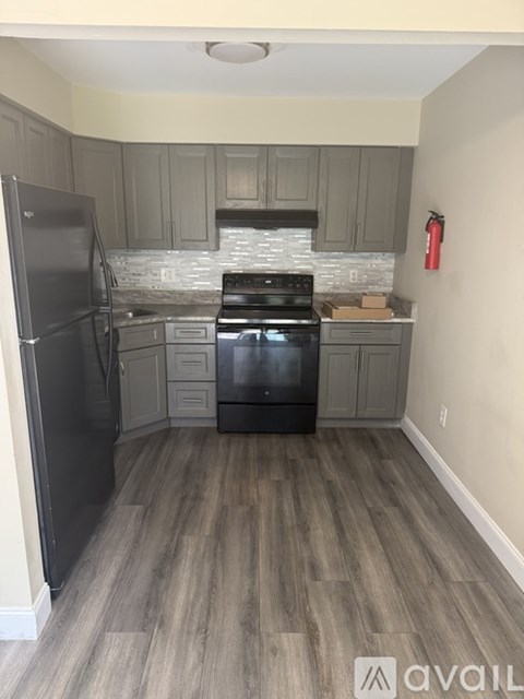 A kitchen with a black stove top oven and a black refrigerator.