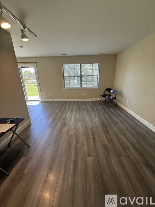 A room with wooden flooring and a window.