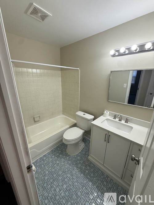 A bathroom with a toilet, sink, and mirror.