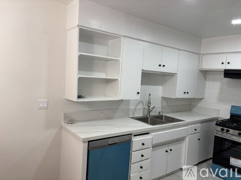 A kitchen with white cabinets and a blue dishwasher.