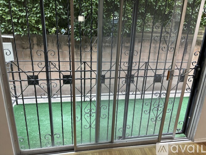 A metal gate with a green lawn in the background.