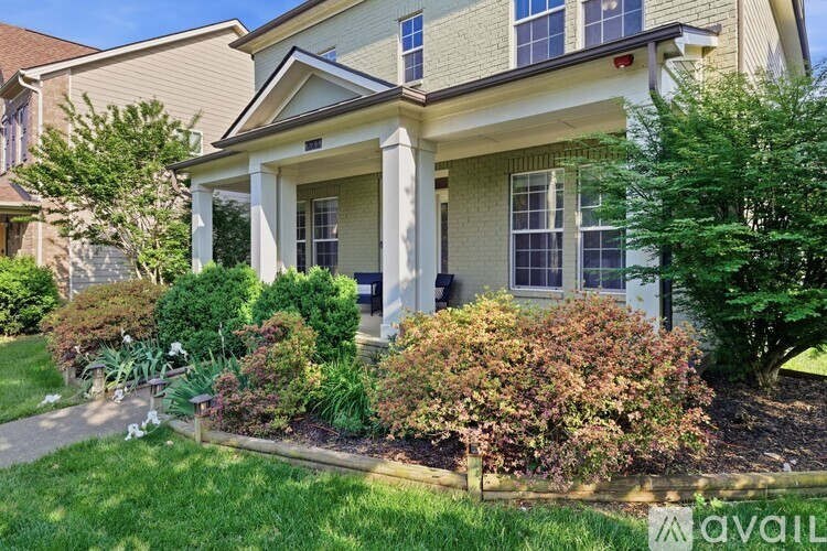 A house with a front yard and landscaping.