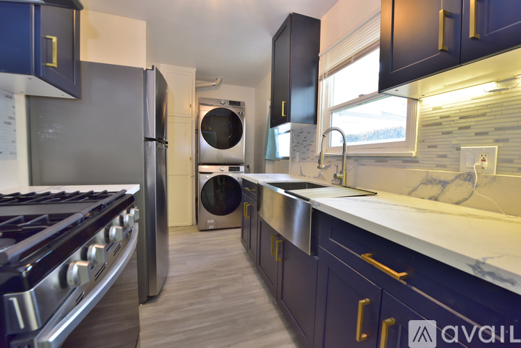 A kitchen with dark blue cabinets and a stainless steel stove.