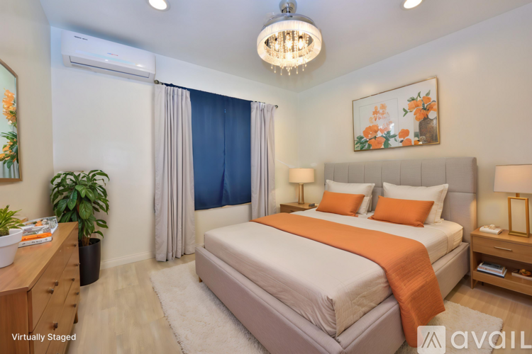 A bedroom with a large bed and a chandelier.