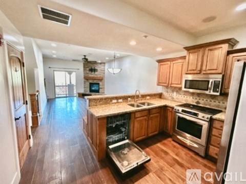 A kitchen with wooden cabinets and a stainless steel refrigerator.
