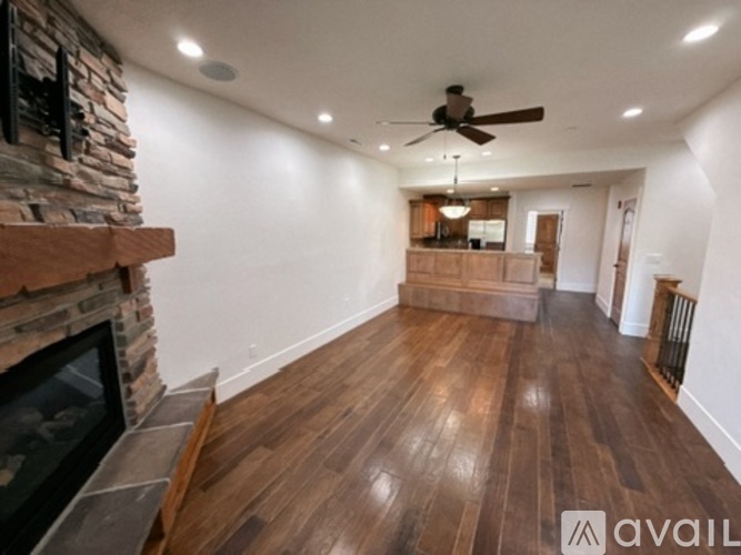 A spacious room with a fireplace and wooden flooring.