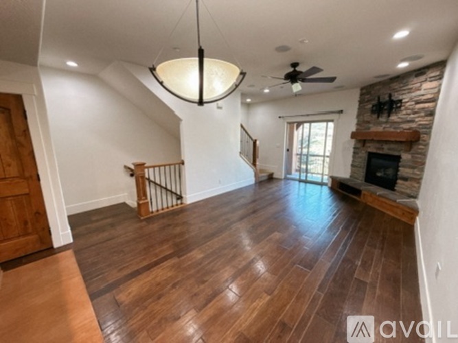 A living room with wooden floors and a fireplace.