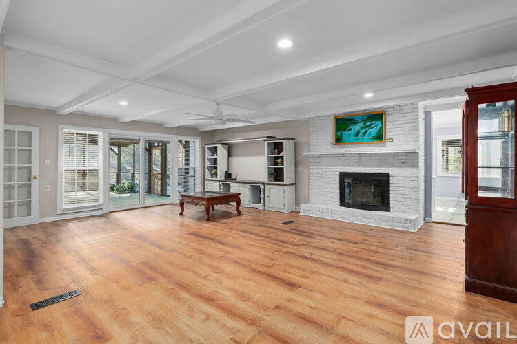 A spacious living room with wood flooring and a fireplace.