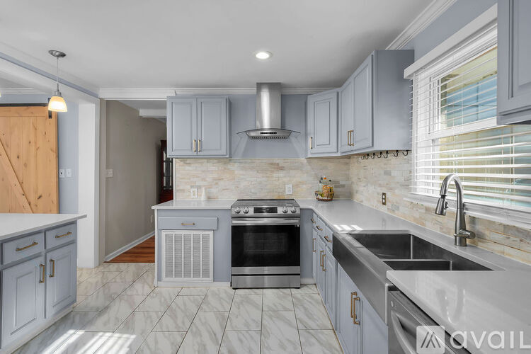 A kitchen with a stove top oven and a range hood.