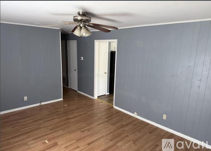 A room with wooden floors and a ceiling fan.