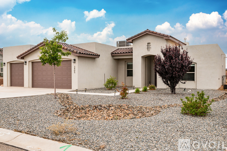 A house with a brown roof and a gravel driveway.