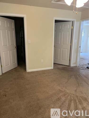 A room with two doors and a carpeted floor.