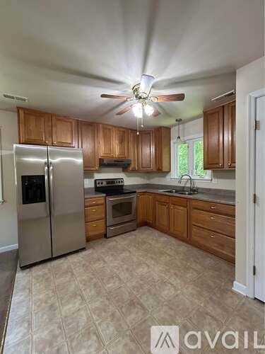 A kitchen with wooden cabinets and a refrigerator.