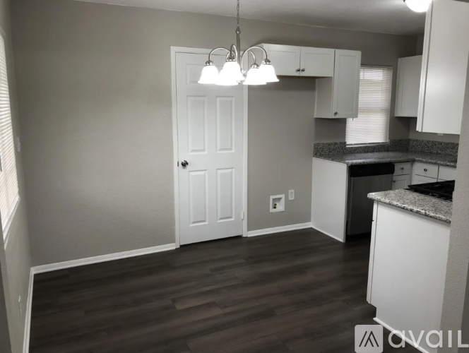 A kitchen with a white door and cabinets.