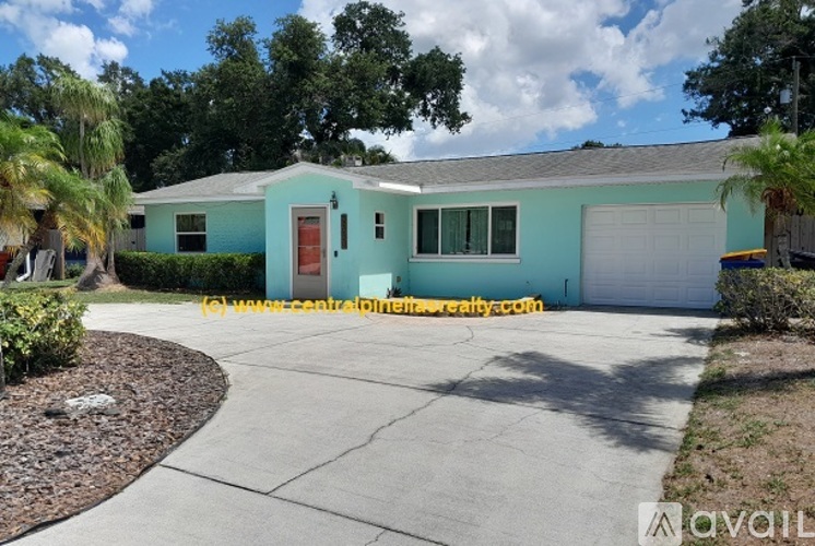 A blue house with a red door and a white garage door.