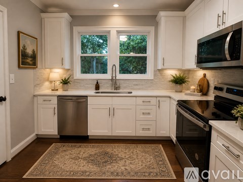 A kitchen with white cabinets and a rug on the floor.