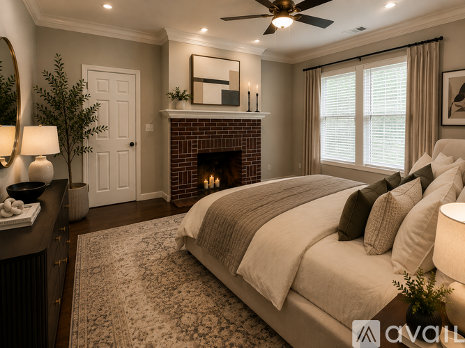 A bedroom with a large bed, a fireplace, and a ceiling fan.