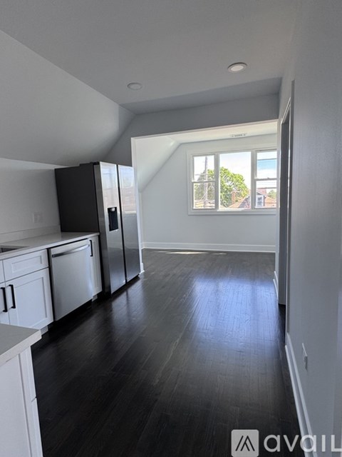 A kitchen with black cabinets and white appliances.
