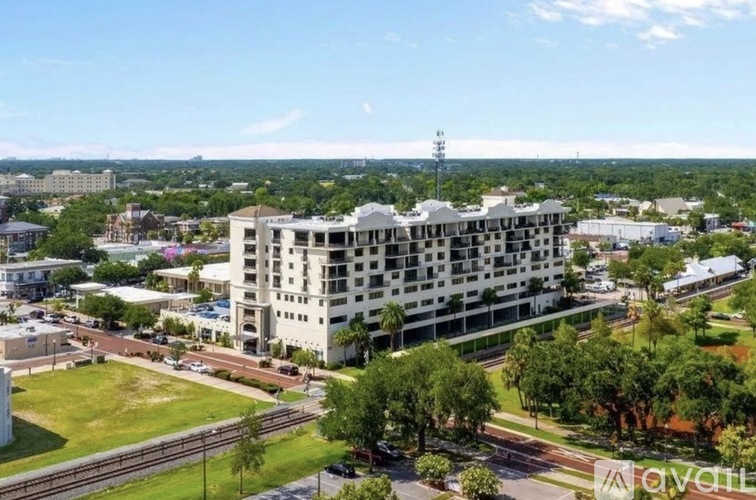 A large white hotel building with a green lawn in front.