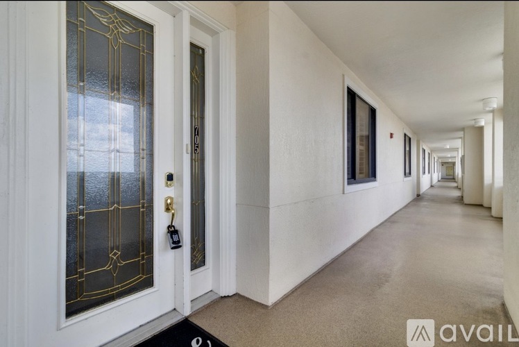 A hallway with white walls and a carpeted floor.