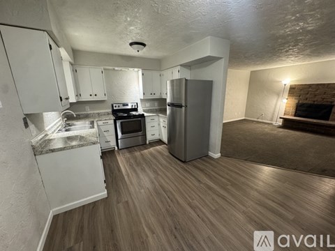A kitchen with white cabinets and a wooden floor.