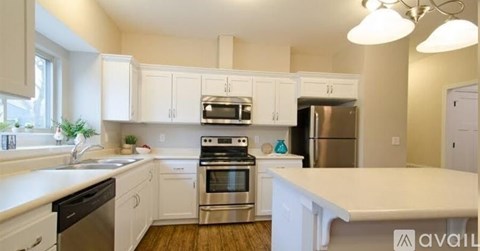 A kitchen with white cabinets and stainless steel appliances.