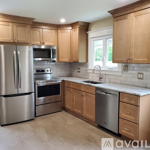 A kitchen with wooden cabinets and a stainless steel refrigerator.