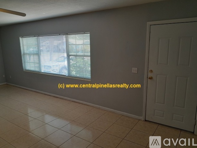 A room with a white door and a window with blinds.