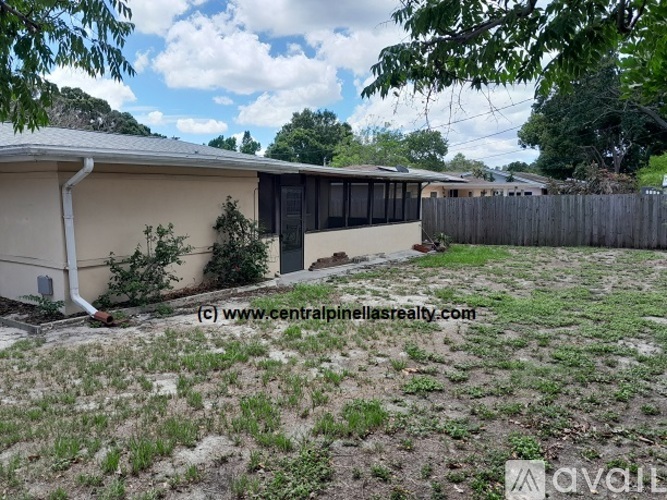A house with a fence and trees in the background.