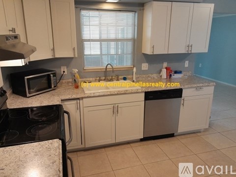 A kitchen with white cabinets and a granite countertop.