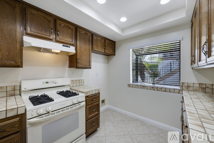A kitchen with white appliances and wooden cabinets.