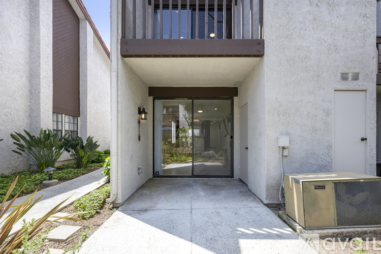 A white building with a glass door and a balcony.