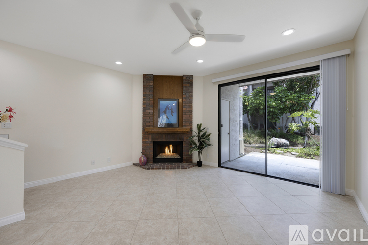 A spacious living room with a fireplace and sliding glass doors leading to a garden.