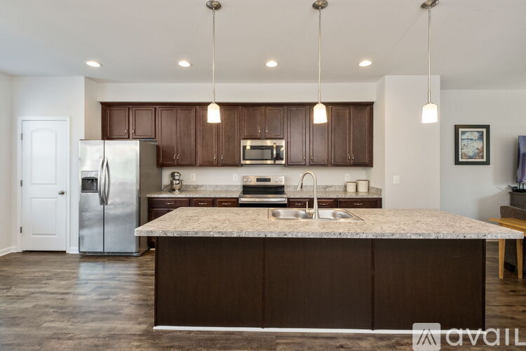 A kitchen with brown cabinets and a granite countertop.