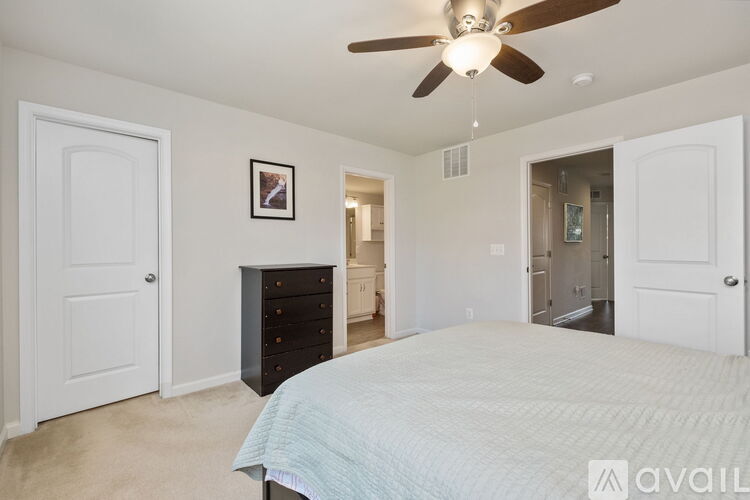 A bedroom with a large bed and a ceiling fan.