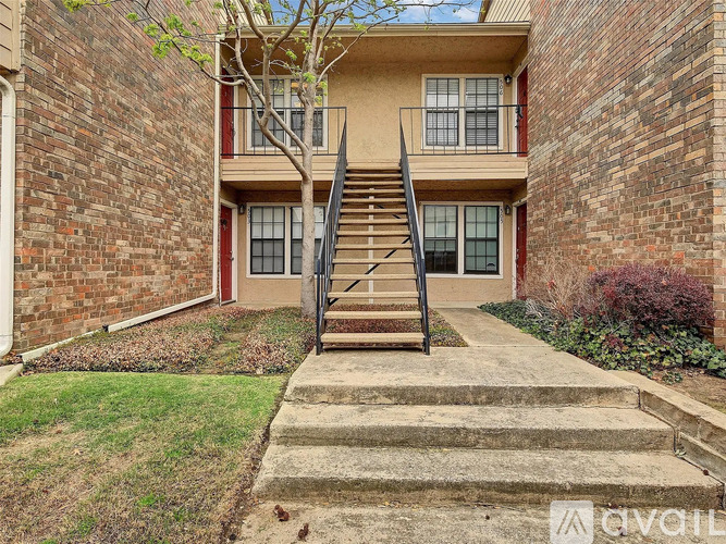 A brick building with a staircase leading to the entrance.