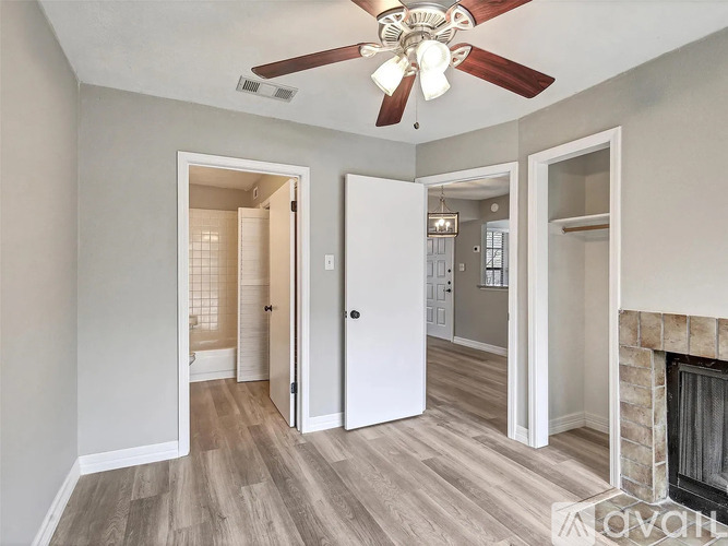 A room with a fireplace and a ceiling fan.