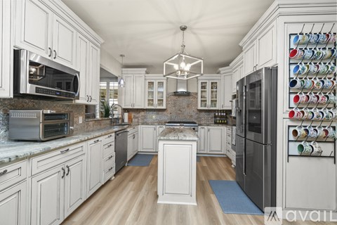 A kitchen with white cabinets and a brick backsplash.