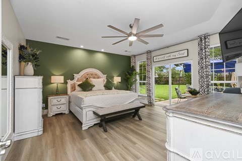 A bedroom with a large bed and a ceiling fan.
