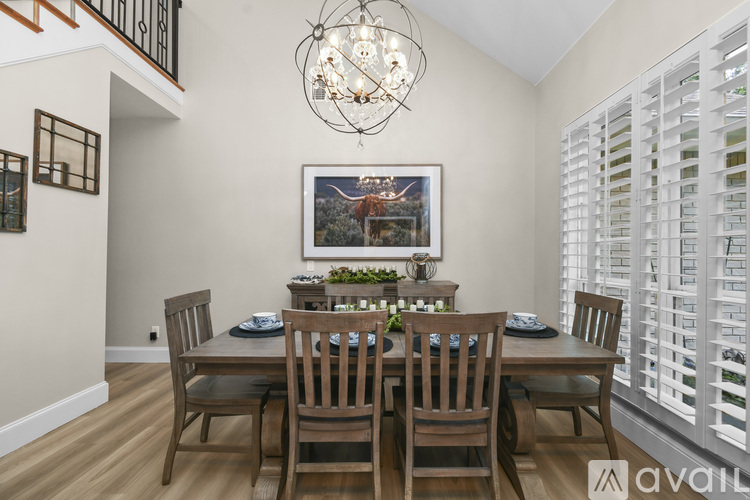 A dining room with a wooden table and chairs.