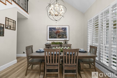 A dining room with a wooden table and chairs.