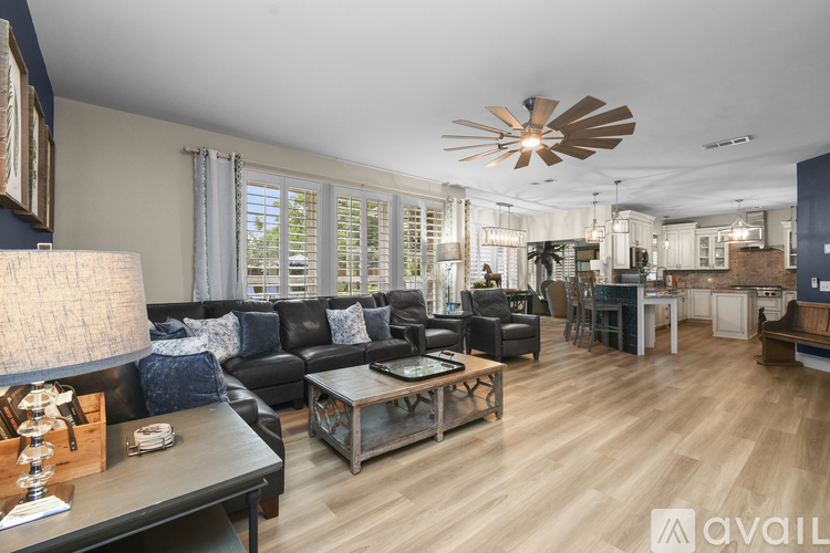A living room with a black couch and a wooden coffee table.