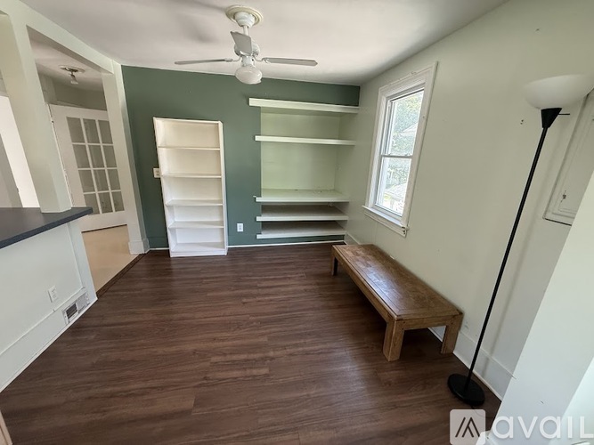A hallway with a trash can and a dog on the floor.